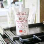 Osius Organic Beef Bone Broth pouch with turmeric on a stovetop, gluten-free and dairy-free