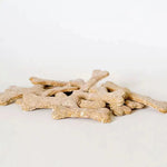 Pile of bone-shaped natural dog treats on a white background